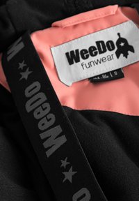 Svart tyg med en rosa innerfoder. Har en "WeeDo funwear" etikett och en svart rem med grå text. Texturerad yta med sömnadsdetaljer.