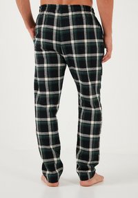 Geruite flanellen broek in zwart, groen en wit. Voorzien van een elastische tailleband en zijzakken, met een relaxte pasvorm en rechte pijpen.