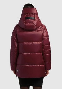 Maroon puffer jacket with a high collar and folded hood, featuring quilted design and logo patch on the back. Smooth, shiny texture.