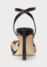 Svarta högklackade sandaler med korsremmar, texturerat svart läder och beige vävda detaljer, med en smal, glansig stilettklack.