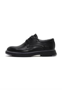 Zapatos de cuero negro con cordones, con punta redonda, superficie texturizada y suela de goma de contraste. Presenta costuras sutiles y un diseño elegante.