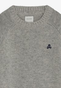Suéter gris de punto con cuello redondo acanalado. Presenta un pequeño logo de calavera y huesos cruzados en el área del pecho izquierdo. Textura suave.