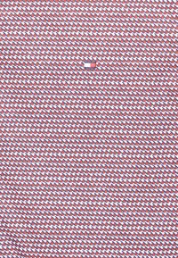 Rood, wit en blauw gestreepte stof met kleine diamanten vormen, met een centraal logo-label. Soepele textuur met een consistente, gelijkmatige uitstraling.