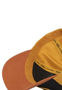 Gorra con una parte delantera marrón y una trasera de malla amarilla texturizada. Presenta un visera curva, interior negro y marca a lo largo del forro interno.