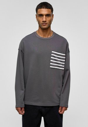 Grijs sweatshirt met lange mouwen, een ronde hals en een gestreepte zak in wit en grijs. Het heeft ribgebreide boorden en een comfortabele pasvorm.
