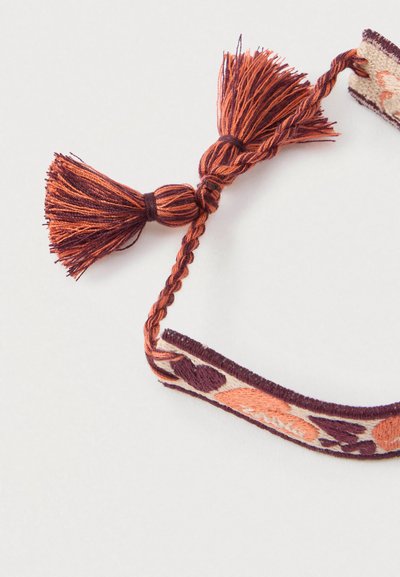 Woven bracelet with orange and purple floral pattern, featuring braided ends and tassels in matching colors. Soft textile material.