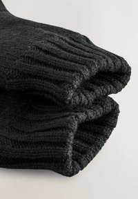 Schwarze gestrickte Handschuhe mit einem strukturierten, gerippten Design. Der Stoff wirkt wollig und dick und hat einen umgeschlagenen Rand für zusätzliche Isolierung.