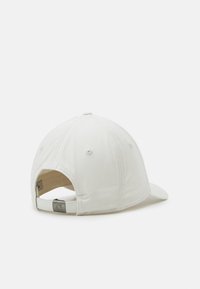 Casquette en coton blanc avec une visière incurvée, bandeau ajustable à l'arrière, couture visible et œillets de ventilation. Design simple, sans motifs.