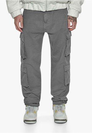Gray cargo pants featuring multiple side pockets, a relaxed fit, and cuffed hems, paired with gray and white sneakers.