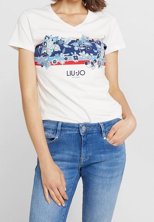 Hvid bomulds t-shirt med V-udskæring, med blå blomsterprint og horisontale farvede striber. Logoet "LIU JО MILANO" trykt nedenfor.