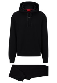 Svart bomullshuvtröja och matchande sweatpants. Har en dragsko i huvan och en liten vit logotyp vid bröstet. Mjuk textur och ribbade manschetter.