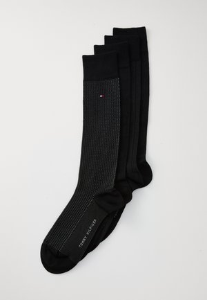 Schwarze Socken-Set mit verschiedenen Texturen; eine Socke hat ein gepunktetes Muster, die anderen sind einfarbig. Enthält das Markenlogo an der Seite.