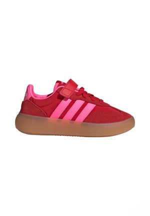 Rode suède sneakers met roze accenten, uitgerust met drie roze strepen, een klittenbandsluiting en een transparante gumzool.