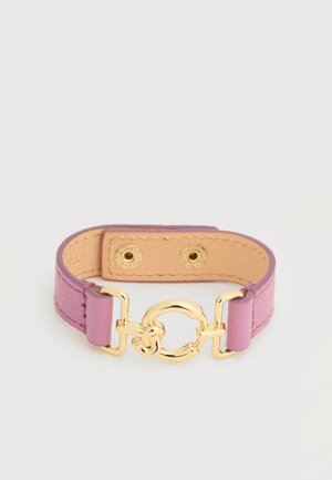 Pink læderarmbånd med guldfarvet rund lukning og to trykknapper på en beige inderforing.