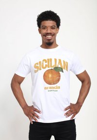 Bílý bavlněný tričko s grafikou "SICILIAN arancia frutta fresca" se oranžovým designem, zeleným detailem listu a texturovaným písmem.