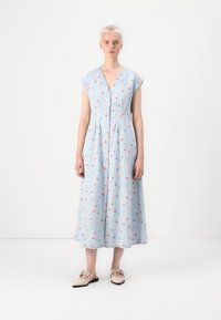 Απαλό μπλε, φόρεμα μέχρι το γόνατο με κοντά μανίκια, κουμπιά μπροστά και λουλουδάτο μοτίβο. Φτιαγμένο από μαλακό ύφασμα με χαλαρή εφαρμογή.