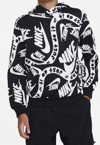 Musta huppari, jossa on rohkea valkoinen Nike-logo kuosi, vetoketjullinen malli, jossa on etutasku sekä ribbaus hihansuissa ja helmassa. Silkkinen pinta.