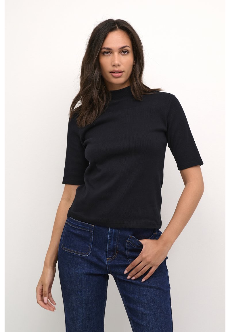 Black ribbed short-sleeve top with a high neckline, paired with blue denim jeans featuring front and back pockets.