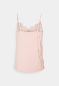 Haut camisole rose clair avec fines bretelles ajustables et détail en dentelle festonnée avec découpes le long de l'encolure sur un fond uni.