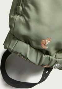 Groene, gestructureerde stoffen tas met een trekkoordsluiting, voorzien van een kleine vosillustratie en een zwarte strap.