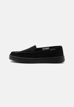 Zwarte slip-on casual schoen met gestikt moc toe ontwerp, doorgestikt zijpaneel, rubberen zool en klein merklabel binnenin en aan de zijkant.