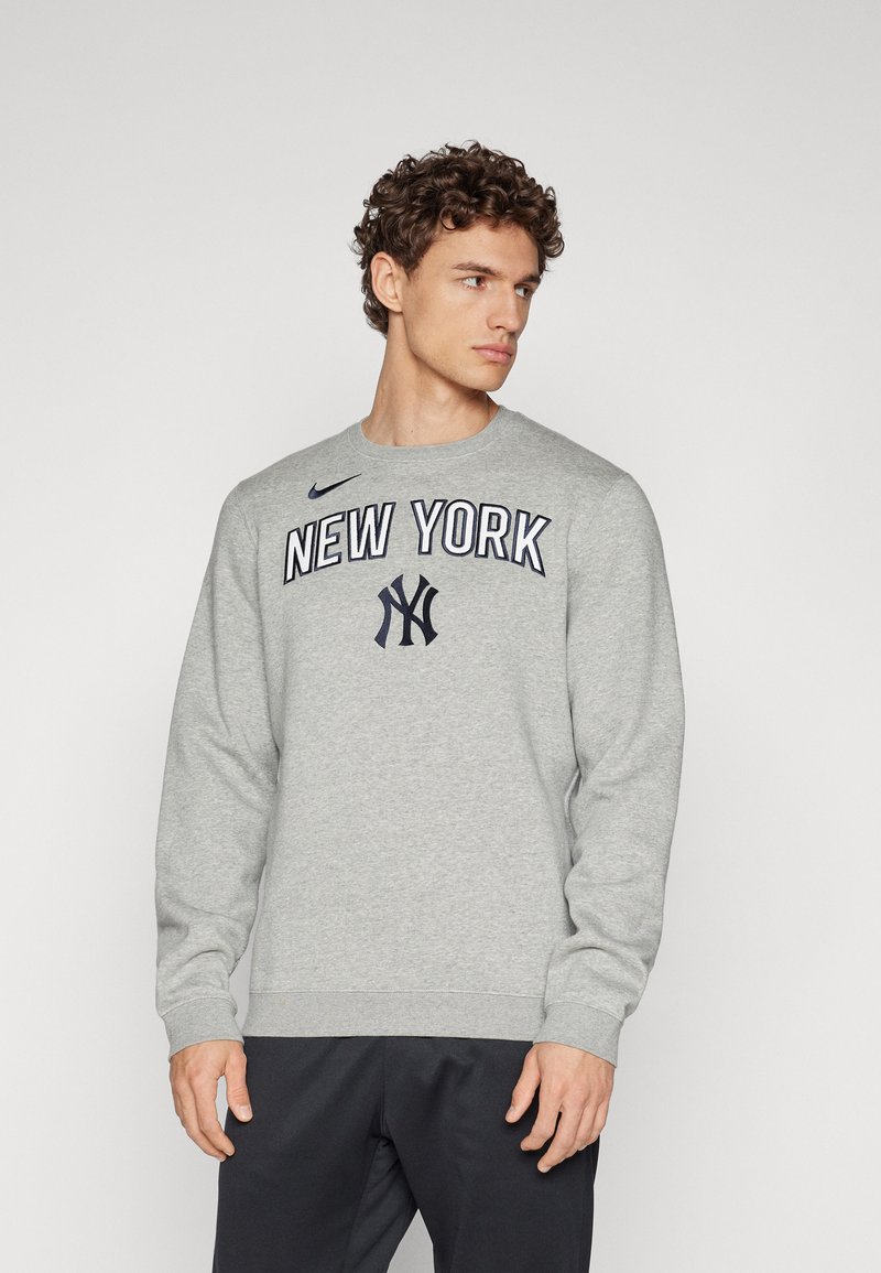 Grå hettegenser med rund hals, lange ermer og "NEW YORK" tekst med logo. Laget av mykt stoff med ribbede mansjetter.