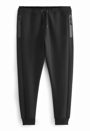Sorte joggingbukser lavet af blødt materiale, med elastisk talje, lynlåslommer og ribbede manchetter. Enkel, tætsiddende design.