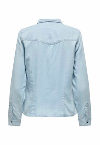 Camisa de mezclilla azul claro con un cuello clásico, mangas largas y puños abotonados. Presenta un canesú y detalles de costura sutiles.