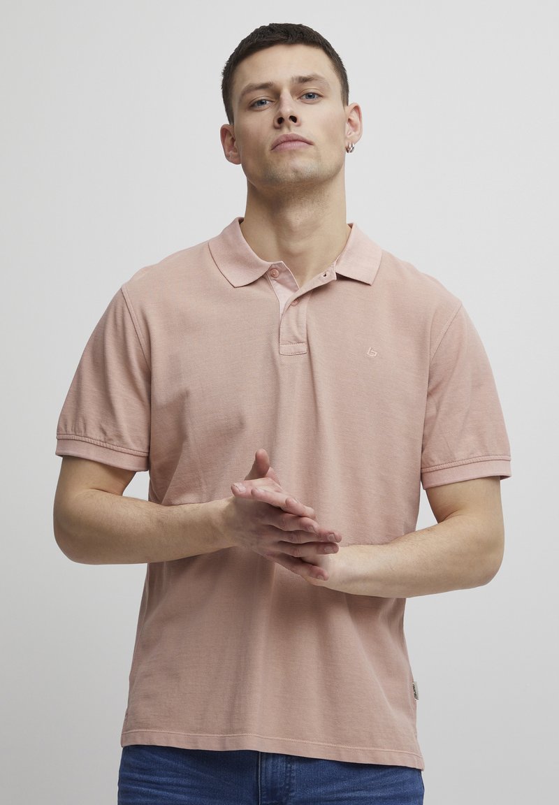 Kortermet polo-skjorte i myk rosa bomull, med en klassisk krage og subtil logo-broderi på brystet. Standard passform med en teksturert finish.