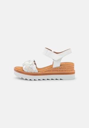 Witte wig sandals met een geweven banddetail. Voorzien van een kurken tussenzool, textuur witte buitenzool en een verstelbare enkelband.