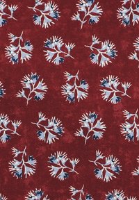 Czerwony materiał o teksturowanej powierzchni, z powtarzającym się kwiatowym wzorem w jasnoniebieskim i granatowym kolorze, ukazujący szczegółowe, rozgałęzione wzory.