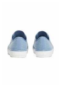 Sneakers blu in tela con superficie testurizzata, suola in gomma bianca e un'etichetta sul tallone con il marchio. Presentano un design low-cut con un rivestimento morbido.
