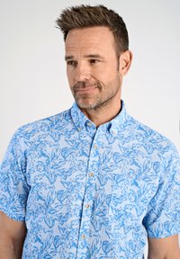 Korte mouwen, knoopsluiting overhemd in lichtblauw met een bloemenpatroon in donkerblauw, gemaakt van lichtgewicht stof met een borstzak.