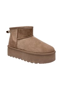 Botte de cheville en daim marron avec une semelle plate, bout rond et une languette à l'arrière. Présente un design simple et lisse.