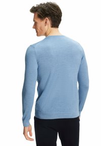 Pull bleu clair en tricot doux, avec des manches longues, un col rond et une texture lisse avec un minimum de détails.