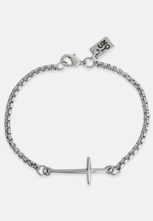 Stříbrný náramek s horizontálním přívěskem kříže. Odkazy na řetízku jsou kulaté a zapínání je ve stylu homáru s brand tagem.