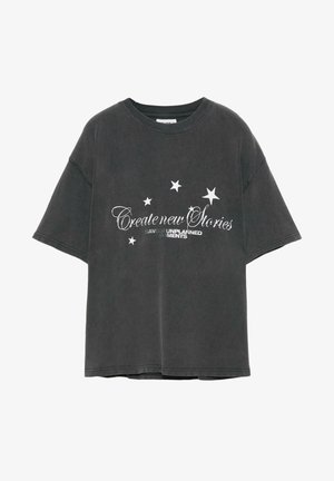 Maglietta oversize grigia scura in cotone con colletto a girocollo. Presenta testo bianco e grafiche a forma di stella. Tessuto morbido con vestibilità rilassata.