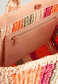 Sac fourre-tout en tissu tissé avec des fils colorés dans des teintes orange, rose et verte, doté d'une poche intérieure en cuir beige lisse avec fermeture éclair.