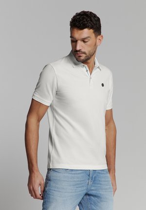 Witte polo t-shirt van ademend materiaal, met een klassieke kraag, drieknoopsluiting met contrasterende accenten en een logo op de borst.