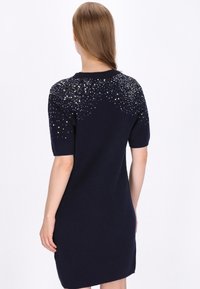Rochie tricotată bleumarin, cu mâneci scurte și un design de paiete embellish pe umeri, cu o croială dreaptă și fante laterale.