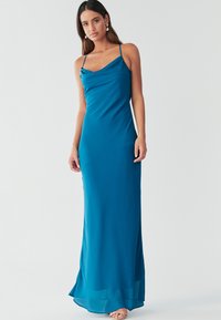 Maksi obleka iz mint satena s tankimi naramnicami, okroglim izrezom in tekočo silhueto, ki se rahlo razširi na spodnjem robu. Gladek oprijem, eleganten dizajn.