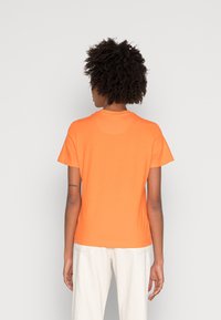 Kortærmet orange T-shirt med rund hals, simpelt design, lavet af blødt bomuldsstof, uden bemærkelsesværdige mønstre eller hardware.