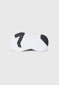 Semelle de chaussure avec une base en caoutchouc blanc texturé et des accents en caoutchouc noir ; présente un motif en zigzag et un grand "7" sur un côté.