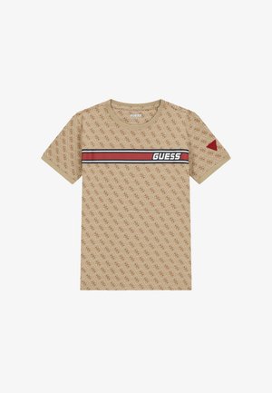 Camiseta de algodón beige con un patrón de logo en toda la prenda, una banda de rayas roja y negra con el texto "GUESS" y un acento triangular rojo en la manga.