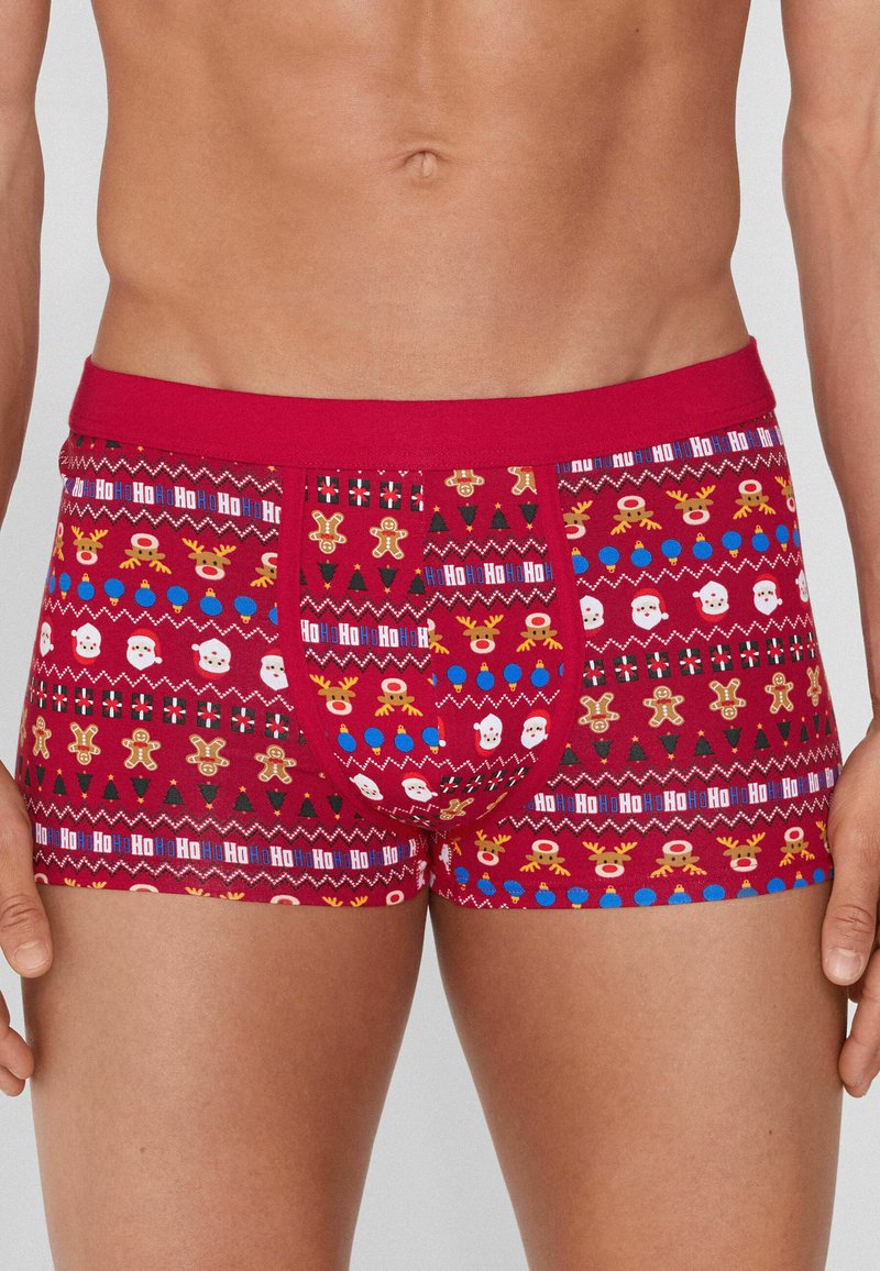 Bóxers rojos para hombre con estampado festivo, que presenta patrones de iconos navideños como renos, Papá Noel y galletas de jengibre. Tela elástica, ajuste ceñido.