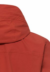 Nahaufnahme des oberen Rückenbereichs einer rostfarbenen Jacke mit Kapuze und sichtbaren Steppnähten.