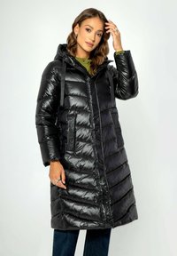 Schwarze Steppjacke mit glänzender Oberfläche, Kapuze und Fronttaschen. Mit horizontaler Steppung und verstellbaren Riemen an der Kapuze.