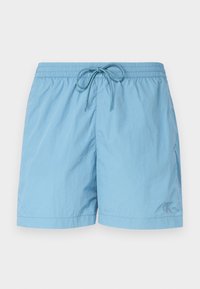 Short de bain bleu clair en tissu léger, doté d'une ceinture élastique avec cordon de serrage et d'un petit logo sur le côté avant gauche.