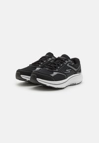 Černé sportovní boty s vrškem z prodyšné síťoviny, šedými akcenty, bílou mezipodešví a texturovanou podešví. Mají šňůrky a polstrovaný límec.