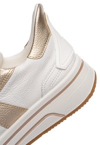 Hvid læder sneakers med metallic guld accenter, tekstureret gummisål og polstret krave for komfort og støtte.